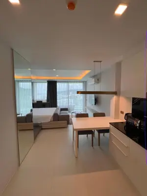 a living room with a couch and a table in a room at Utopia Karon Sea View Apartments in Karon Beach