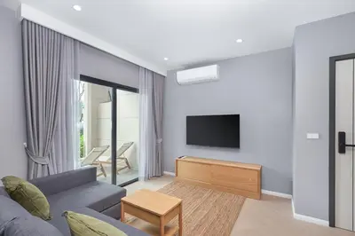 a living room with a couch and a tv at Title Legendary Bang Tao by My Home Phuket in Ban Nong Chaeng