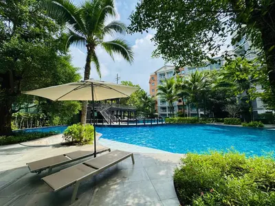 a swimming pool with a bench and an umbrella at Cozy studio Pool View near of NaiYang beach in Nai Yang Beach
