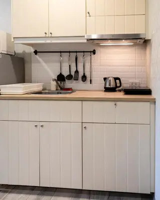 a kitchen with white cabinets and a sink at Cozy studio Pool View near of NaiYang beach in Nai Yang Beach