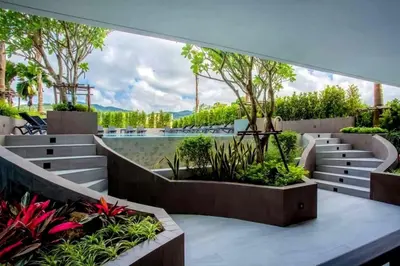 a view of a garden with benches and plants at Modern 61m² Apt - Central Chalong/ Fast WiFi in Ban Thalat Choeng Thale