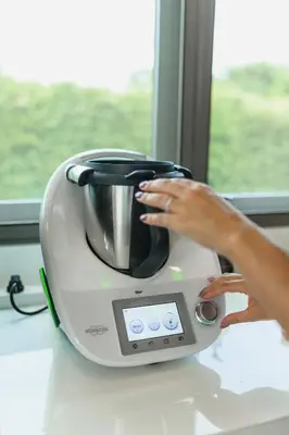a woman is using a toaster on a counter at Villa Mimosa 4 - Luxury 4BR Private Pool - Rawai in Kata Beach