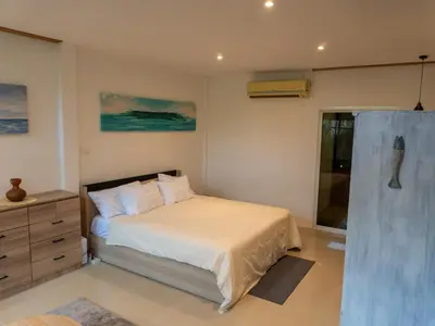 a bedroom with a bed and a dresser and a window at The Fifth Bamboo in Laguna Phuket