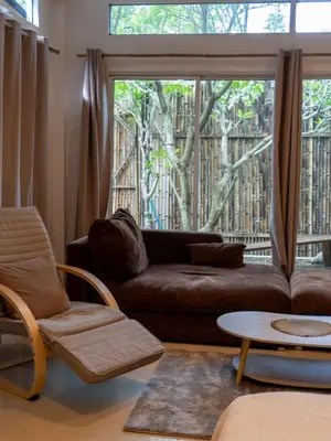 a living room with a couch and chairs and a large window at The Fifth Bamboo in Laguna Phuket
