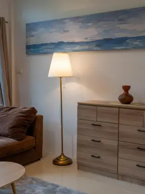 a living room with a lamp next to a dresser at The Fifth Bamboo in Laguna Phuket