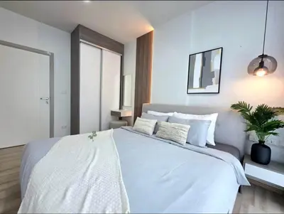 a bedroom with a large white bed with a potted plant at The Modern central Phuket base condo by luxStays in Ban Rangeng