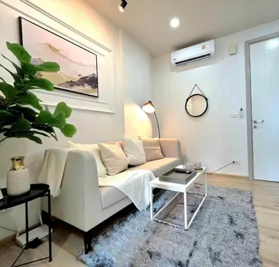 a living room with a couch and a table at The Modern central Phuket base condo by luxStays in Ban Rangeng