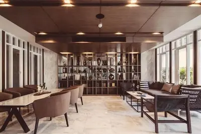 a dining room with tables and chairs and a library at The Modern central Phuket base condo by luxStays in Ban Rangeng