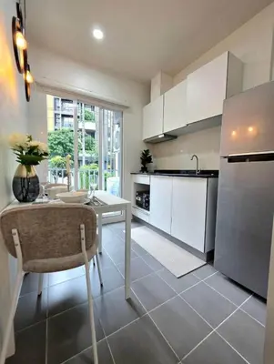 a kitchen with a table and a kitchen with white cabinets at The Modern central Phuket base condo by luxStays in Ban Rangeng