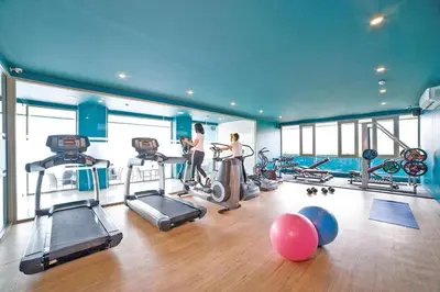 two women in a gym with treadmills and exercise bikes at Modern condo with full sea view, 4 min walk to Kamala beach in Kamala Beach
