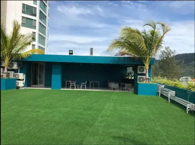 a house with a green lawn in front of it at Modern condo with full sea view, 4 min walk to Kamala beach in Kamala Beach