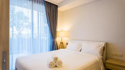 a bedroom with a bed with towels on it at Стильные апартаменты с террасой in Laguna Phuket