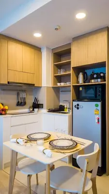 a kitchen with a table with two chairs and a refrigerator at Стильные апартаменты с террасой in Laguna Phuket