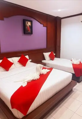a bedroom with two beds with red and white pillows at Nova Patong in Patong Beach
