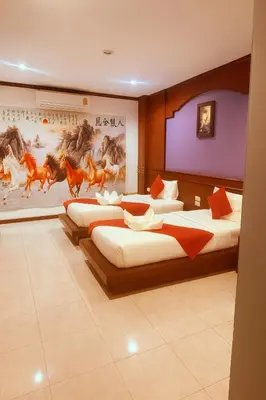 a room with three beds and a painting of horses at Nova Patong in Patong Beach