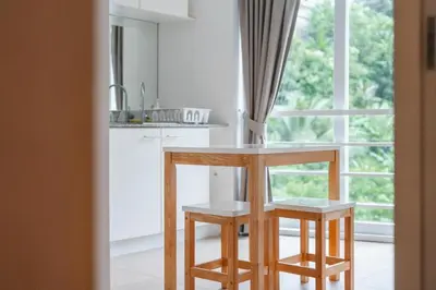 a kitchen with a table and two chairs in front of a window at Kata Beach Tropical Hillside Retreat Jungle View in Kata Beach