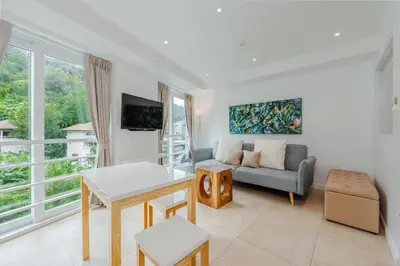 a living room with a couch and a table at Kata Beach Tropical Hillside Retreat Jungle View in Kata Beach