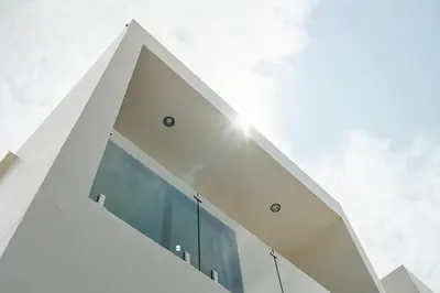 a white building with the sun in the sky at Tropical Holiday Retreat 1BR Villa Near Bangtao in Ban Pak Lak