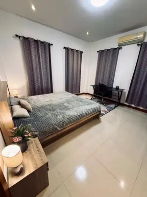 a bedroom with a bed and a desk in it at Cozy family cottage w pool Bang Tao in Phuket