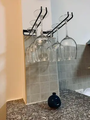 a group of wine glasses hanging on a rack at Cozy family cottage w pool Bang Tao in Phuket