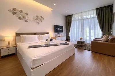 a bedroom with a large white bed and a couch at Goldena Twin Private Villas - Duplex Villa with Sauna, Kamala in Kamala Beach