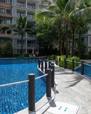 a swimming pool in front of a building at Comfy studio - 10 min walk to NaiYang Beach in Nai Yang Beach