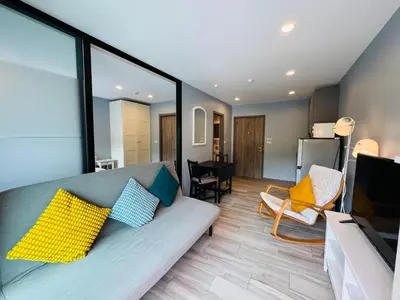 a living room with a couch with pillows on it at Comfy studio - 10 min walk to NaiYang Beach in Nai Yang Beach