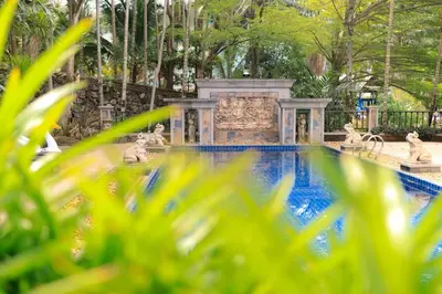 a swimming pool in a garden with a fountain at Classic Cozy Thai Villa BIG pool Party OK in Patong Beach