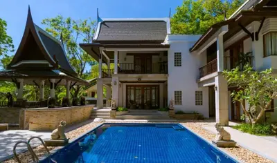 a house with a swimming pool in front of a house at Classic Cozy Thai Villa BIG pool Party OK in Patong Beach