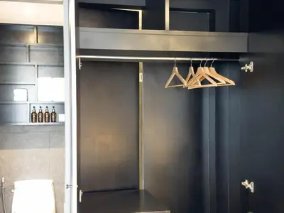 a kitchen with black walls and a metal door with hangers at Citygate Apartament in Kamala Beach