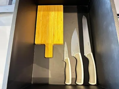 a box with three knives and a cutting board at Citygate Apartament in Kamala Beach