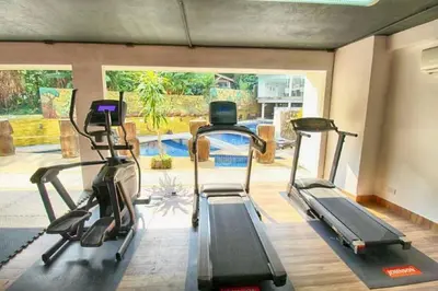 a gym with three treadmills and a swimming pool at Studio apartment in Patong, Phuket in Patong Beach