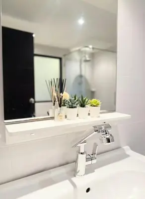 a bathroom sink with a mirror and plants on a shelf at Studio apartment in Patong, Phuket in Patong Beach