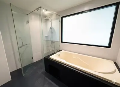 a bathroom with a tub and a glass shower at Studio apartment in Patong, Phuket in Patong Beach