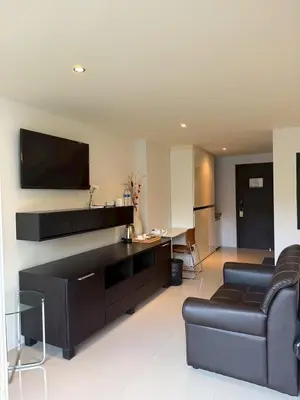 a living room with a couch and a tv at Studio apartment in Patong, Phuket in Patong Beach