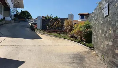 an empty street with a brick wall and a driveway at Studio apartment in Patong, Phuket in Patong Beach