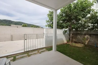 a white porch with a white fence and a tree at Ali Cozy Houses in Ban Thalat Choeng Thale