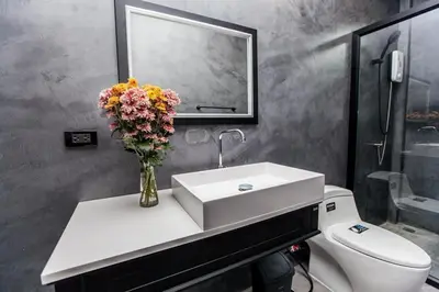 a bathroom with a sink and a vase of flowers at Ali Cozy Houses in Ban Thalat Choeng Thale