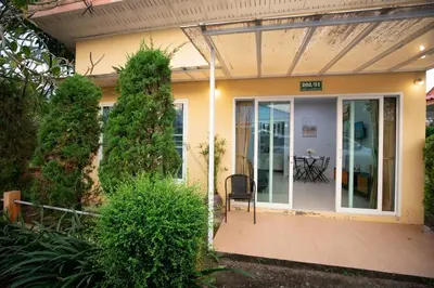a house with a glass door and a chair on a porch at cozy Best house with garden near Bang Tao beach in Ban Thalat Choeng Thale