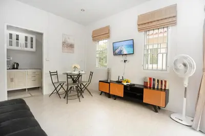 a living room with a table and a kitchen at cozy Best house with garden near Bang Tao beach in Ban Thalat Choeng Thale