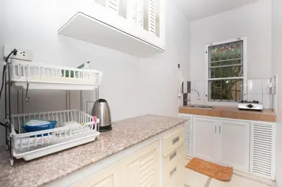 a kitchen with white cabinets and a sink at cozy Best house with garden near Bang Tao beach in Ban Thalat Choeng Thale