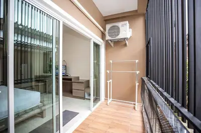 a room with a balcony with a bed and a fan at RICH house in Ban Thalat Choeng Thale