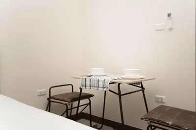 a small table and two chairs in a room at RICH house in Ban Thalat Choeng Thale