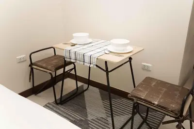 a small table with two chairs and two bowls on it at RICH house in Ban Thalat Choeng Thale