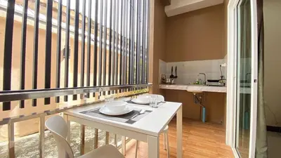a white table and chairs in a room with a large window at RICH house in Ban Thalat Choeng Thale