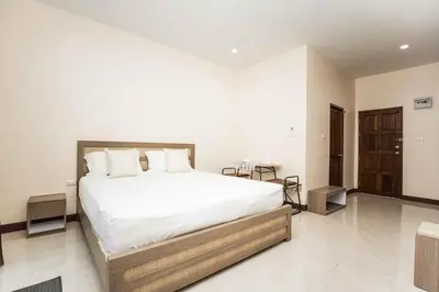 a bedroom with a large bed with white sheets at RICH house in Ban Thalat Choeng Thale