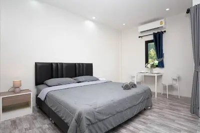 a bedroom with a large bed and a window at Cozy Bonaparte Studios in Ban Thalat Choeng Thale