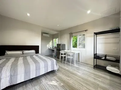 a bedroom with a bed and a table in it at VISUT apartments near mountain in Ban Thalat Choeng Thale