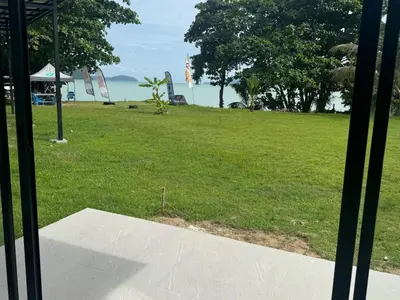 a view from a window of a field of grass at Sunrise Beachfront Rawai in Ban Saiyuan (1)