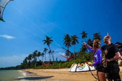 a man and woman flying a kite on the beach at Sunrise Beachfront Rawai in Ban Saiyuan (1)